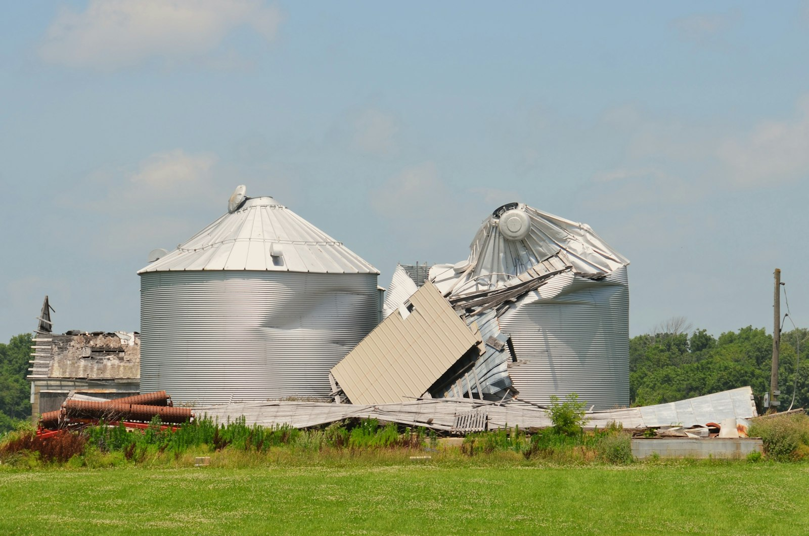 Grain bins and an agricultural building damaged by a severe storm